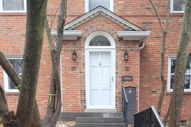 Front of old brick home with new concrete path and foundation